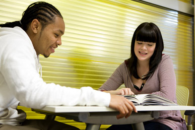 Two students reading at table